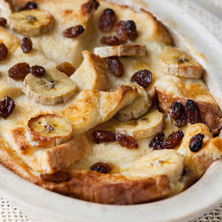 Baked bread and butter pudding made with sliced banana and sultanas.
